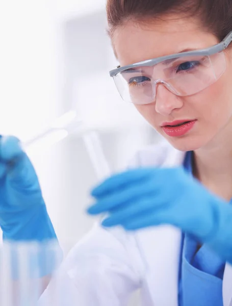 Woman researcher is surrounded by medical vials and flasks, isolated on white background — Stock Photo, Image