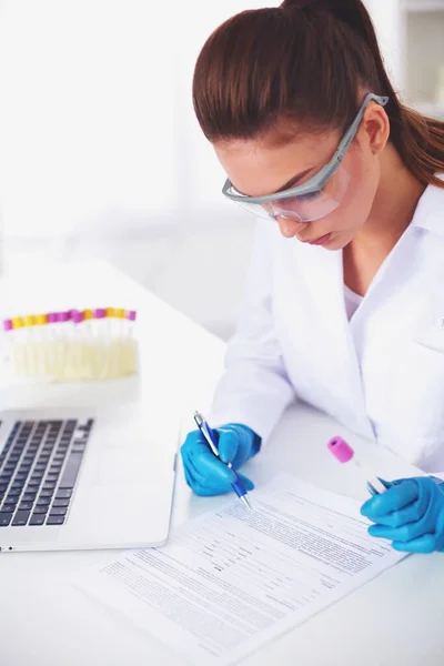 Женщина-исследователь окружена медицинскими ампулами и колбами, изолированными на белом фоне — стоковое фото