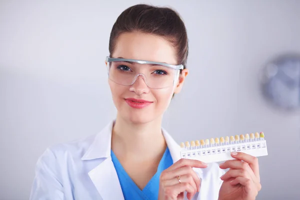 Красивая женщина врач держит отбеливающий инструмент для зубов . — стоковое фото