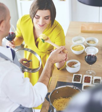 Evdeki mutfakta birlikte yemek pişiren çift.