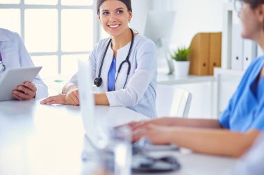 Doktorlar hastane konferans odasında birbirlerine danışıyorlar.