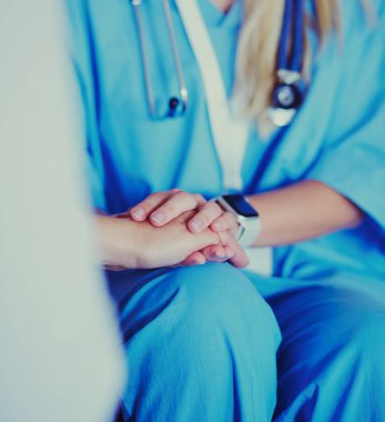 Kadın doktor yaşlılara hastanede el ele tutuşmalarında yardım ediyor