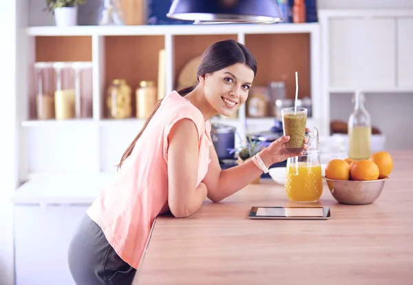 Όμορφη νεαρή γυναίκα χρησιμοποιώντας ένα ψηφιακό tablet στην κουζίνα — Φωτογραφία Αρχείου