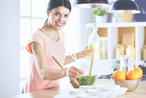 Junge Frau in der Küche mit Laptop-Computer sucht Rezepte, lächelt. Food-Blogger-Konzept — Stockfoto