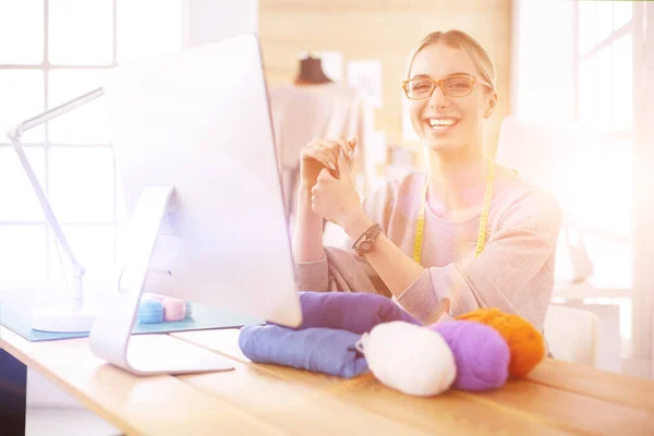 Fashion designer vrouw werken in de studio, zitten aan het bureau — Stockfoto