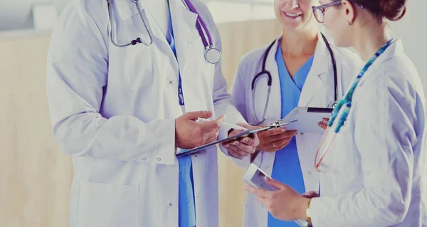 Доктор показує щось у планшеті своїй медичній команді — стокове фото