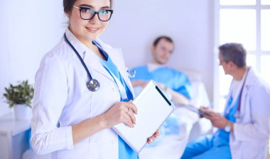 Hastane lobisinde tablet bilgisayar kullanan kadın doktor.