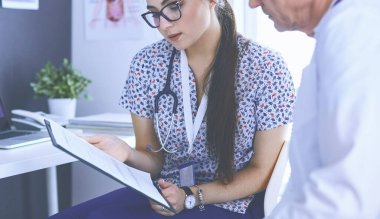 Parlak bir ofiste konuşan iki doktor.