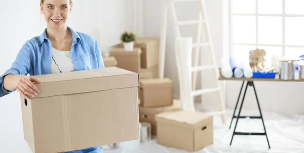 Mladá žena, stěhování do nové domácí hospodářství kartonové krabice — Stock fotografie