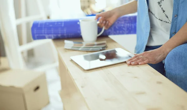 Mujer joven sentada en casa y comprando muebles nuevos a través de Internet usando una tableta — Foto de Stock