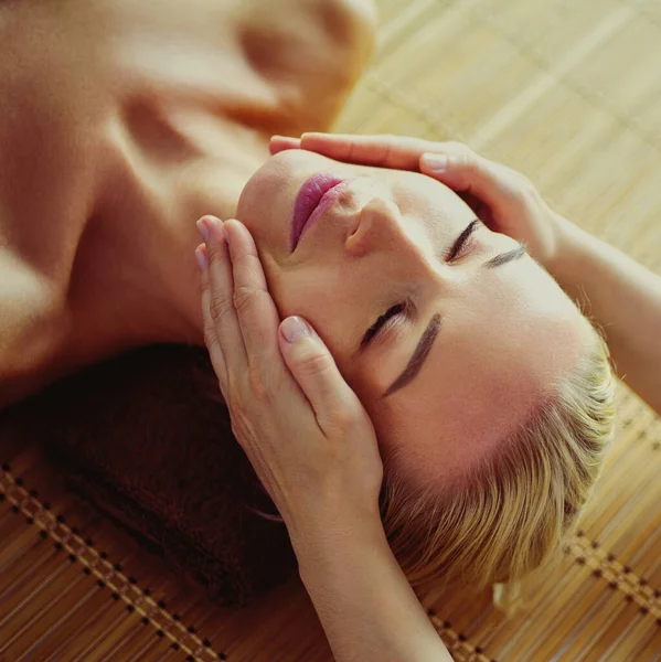 Beautiful woman doing facial massage in a spa salon — Stock Photo, Image