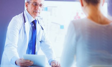 Doktor bey ve hasta muayenehanesinde.