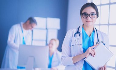 Hastane lobisinde tablet bilgisayar kullanan kadın doktor.