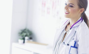 Üniformalı tıbbi bir steteskopla gülümseyen kadın doktor.