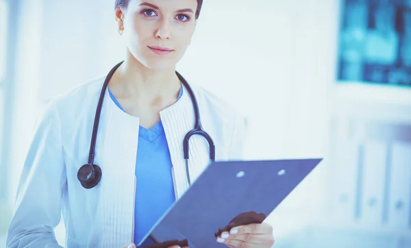 Unga leende kvinnlig läkare med stetoskop hålla en mapp på läkare kontor — Stockfoto