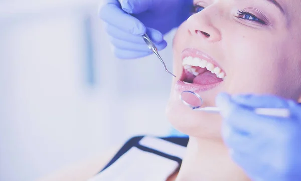 Ung kvinnelig pasient med åpen munn som undersøker tannlegeundersøkelsen. – stockfoto
