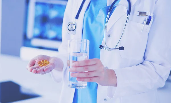 Coup de mains de médecins tenant des pilules et un verre d'eau à la clinique. — Photo