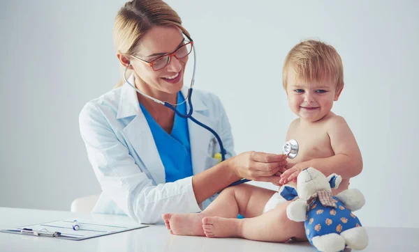 Ženský doktor poslouchá dítě se stetoskopem na klinice — Stock fotografie