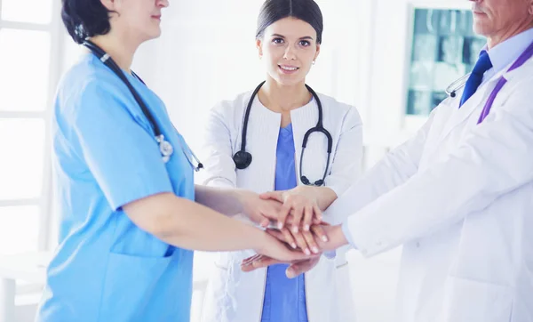 Orvosok csoportja, akik egymás kezét nyújtják. — Stock Fotó