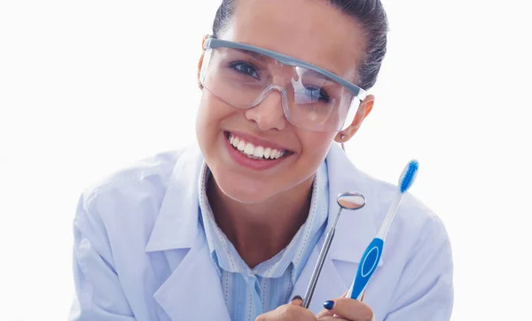 Piękna lekarka dentystka trzymająca i pokazująca szczoteczkę wyizolowaną na białym tle. Lekarz dentysta — Zdjęcie stockowe