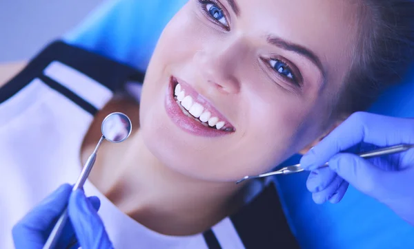 Jonge vrouwelijke patiënt met mooie glimlach onderzoeken tandheelkundige inspectie bij tandarts kantoor. — Stockfoto