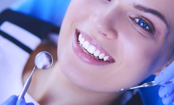 Young Female patient with pretty smile examining dental inspection at dentist office.