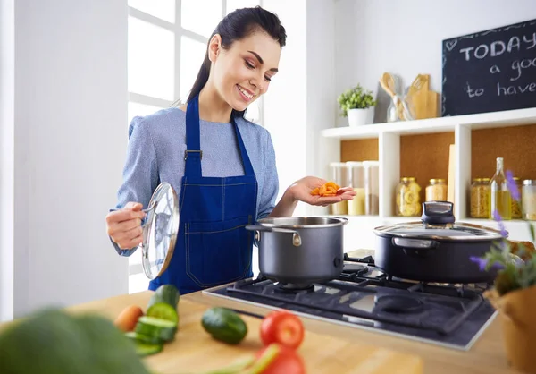 Koken vrouw in keuken met houten lepel — Stockfoto