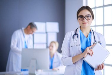 Hastane lobisinde tablet bilgisayar kullanan kadın doktor.