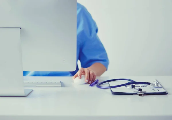 Nieznana kobieta lekarz wypełniając formę medyczną siedząc przy biurku w biurze szpitalnym — Zdjęcie stockowe