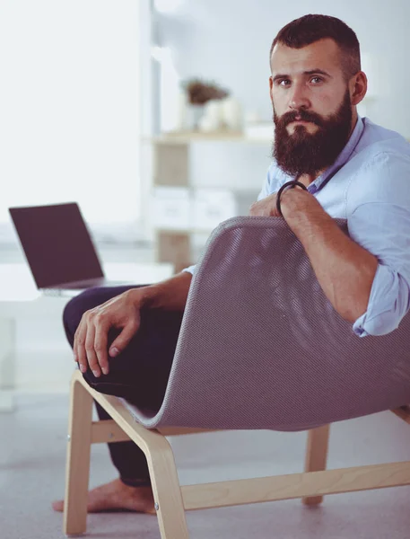 Retrato de un hombre sonriente relajándose en la silla en casa —  Fotos de Stock