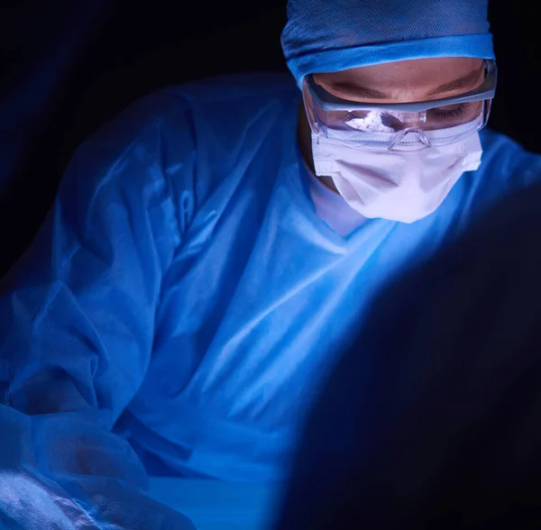 어두운 배경에서 수술을 하는 의사. — 스톡 사진