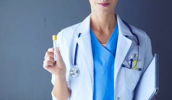 Medizinische oder wissenschaftliche Wissenschaftlerin oder Ärztin mit Blick auf ein Reagenzglas mit klarer Lösung in einem Labor oder Labor. — Stockfoto