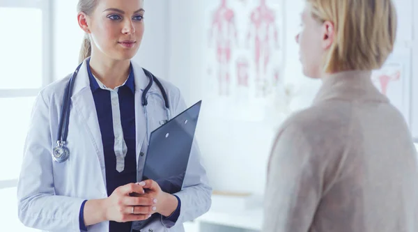 Dokter en patiënt bespreken iets terwijl ze aan tafel zitten. Begrip "geneeskunde en gezondheidszorg" — Stockfoto