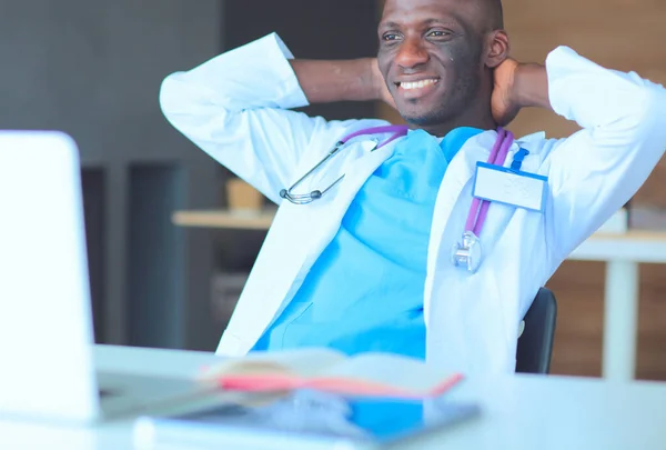 Joven médico africano trabajando en portátil en el escritorio — Foto de Stock