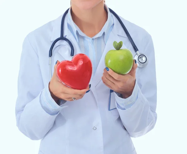 Mooie glimlachende vrouwelijke arts met rood hart en groene appel — Stockfoto