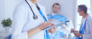 Hastane lobisinde tablet bilgisayar kullanan kadın doktor.