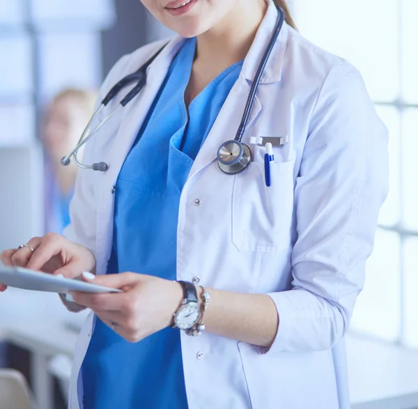 Médico femenino usando tableta en el vestíbulo del hospital —  Fotos de Stock