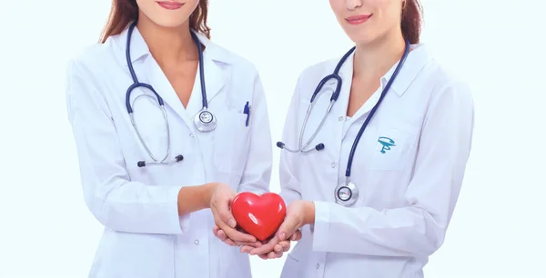 Dos doctora sosteniendo un corazón rojo, aislada sobre fondo blanco —  Fotos de Stock