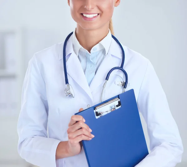 Усміхнена жінка-лікар з папкою в уніформі, стоячи в лікарні — стокове фото