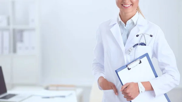 Sorridente medico donna con una cartella in uniforme in piedi in ospedale — Foto Stock