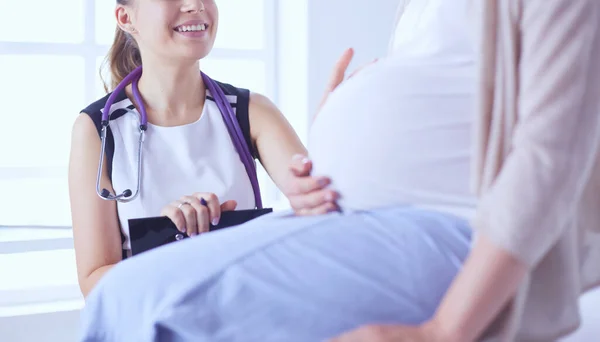 Giovane donna medico con stetoscopio e tablet che parla con una donna incinta in ospedale. — Foto Stock