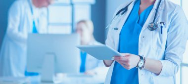 Hastane lobisinde tablet bilgisayar kullanan kadın doktor.