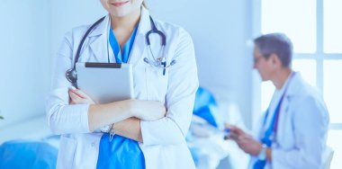 Hastane lobisinde tablet bilgisayar kullanan kadın doktor.