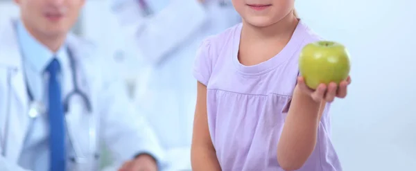 아동 및 약학 개념 - 여자 의사가 어린 소녀에게 사과를 주는 모습 — 스톡 사진