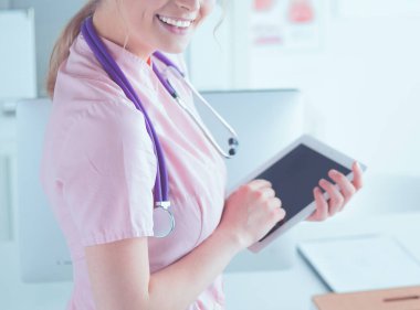 Hastanede tablet bilgisayar kullanan güzel bir kadın sağlık görevlisi.