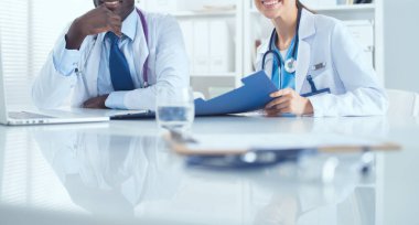 İki doktor bir tıp bürosunda önemli bir dosya üzerinde çalışıyor.