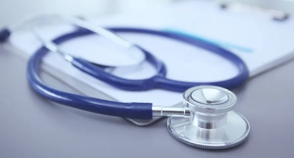 Stethoscope with black medical clipboard on wooden desk — Stock Photo, Image