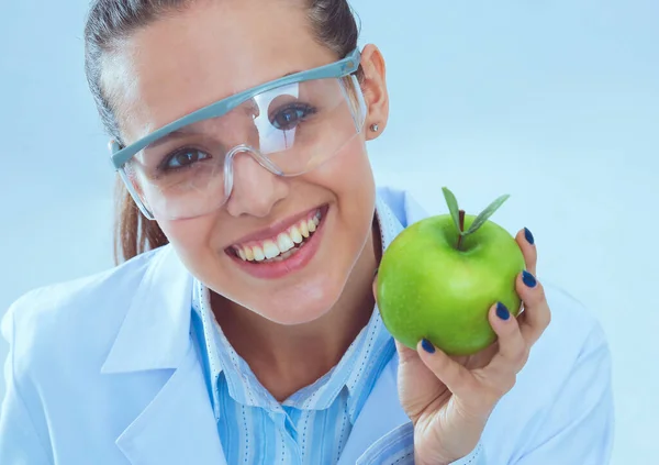 歯医者の女性は手と歯ブラシで緑の新鮮なリンゴを保持しています。歯医者だ。女性医師 — ストック写真