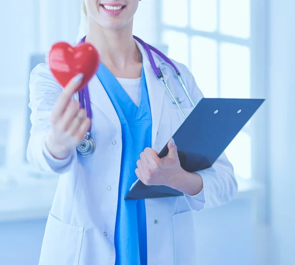 Médica com o estetoscópio segurando o coração — Fotografia de Stock