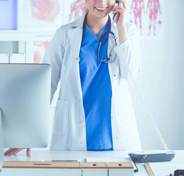 Serieuze dokter aan de telefoon in haar kantoor — Stockfoto